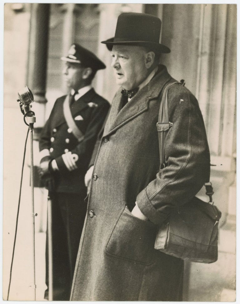 Item #005249 An original wartime press photograph of Prime Minister Winston S. Churchill on 12 May 1942 addressing the Parliamentary Home Guard in London while carrying his gas mask