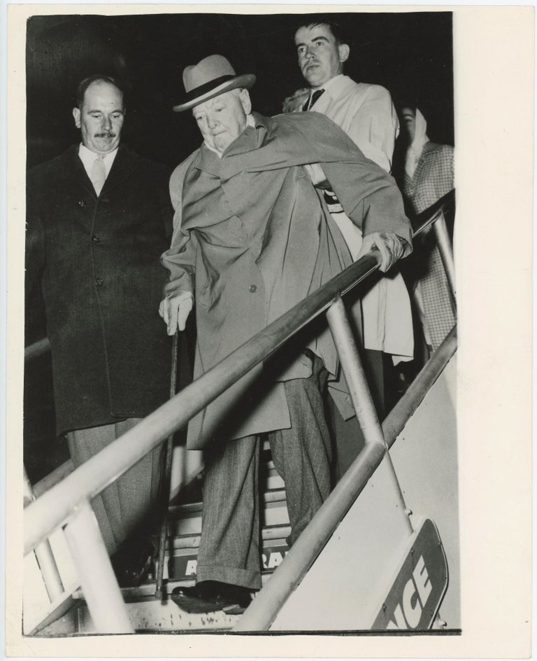 Item #005384 An original press photo of Sir Winston S. Churchill on 29 September 1960 being helped to disembark from the aircraft in which he arrived in Nice for a holiday