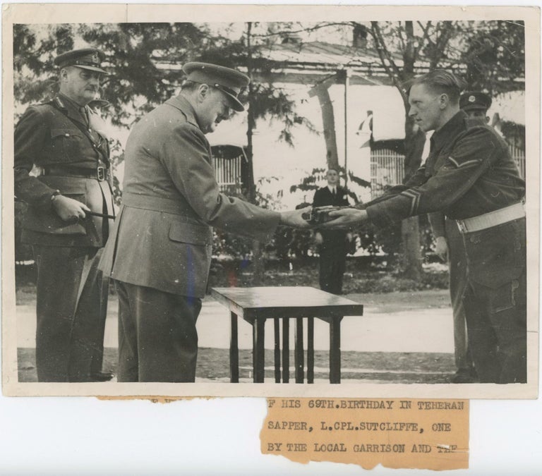 Item #005652 A British Official wartime press photograph of Prime Minister Winston S. Churchill receiving a gift from a British soldier during the Tehran Conference with Stalin and Roosevelt on 30 November 1943, Churchill's 69th birthday