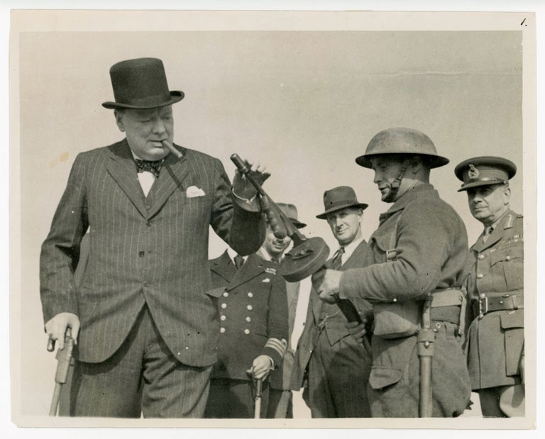 Item #006607 Mr. WINSTON CHURCHILL VISITS THE NORTH EAST - A Second World War British Official War Office photograph of Prime Minister Winston S. Churchill on 13 August 1940 examining a Thompson submachine gun during a defence works tour in the North East of England
